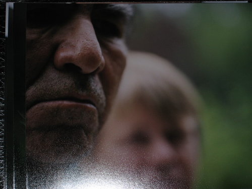 Close detail of a photographic component from the installation, showing two partially obscured faces at different depths