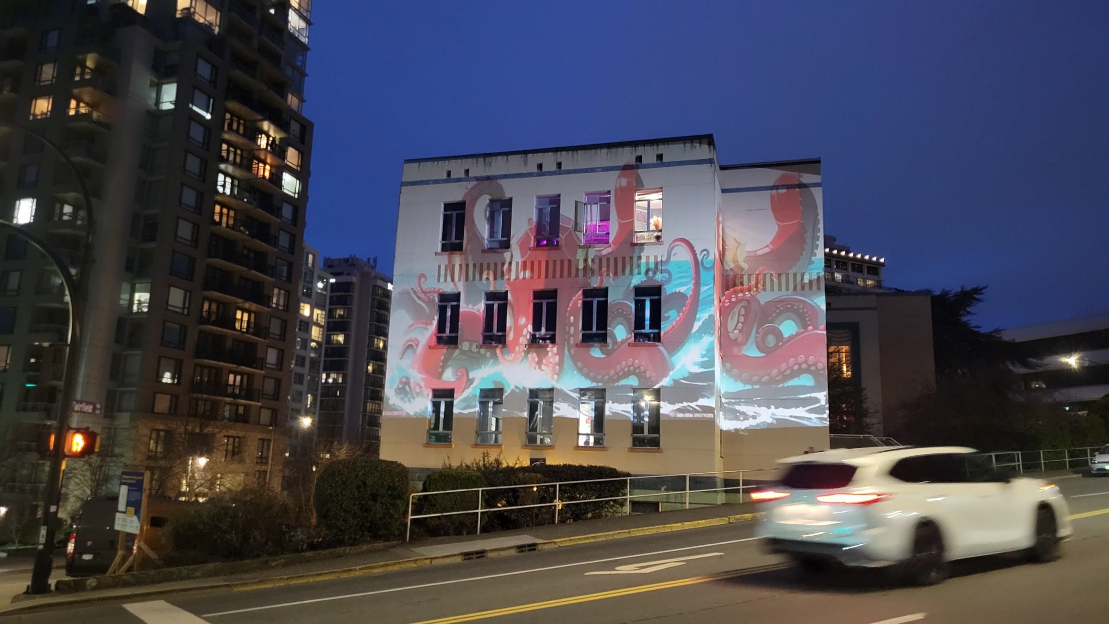 Large-scale aquatic imagery projected across the exterior of a building at night